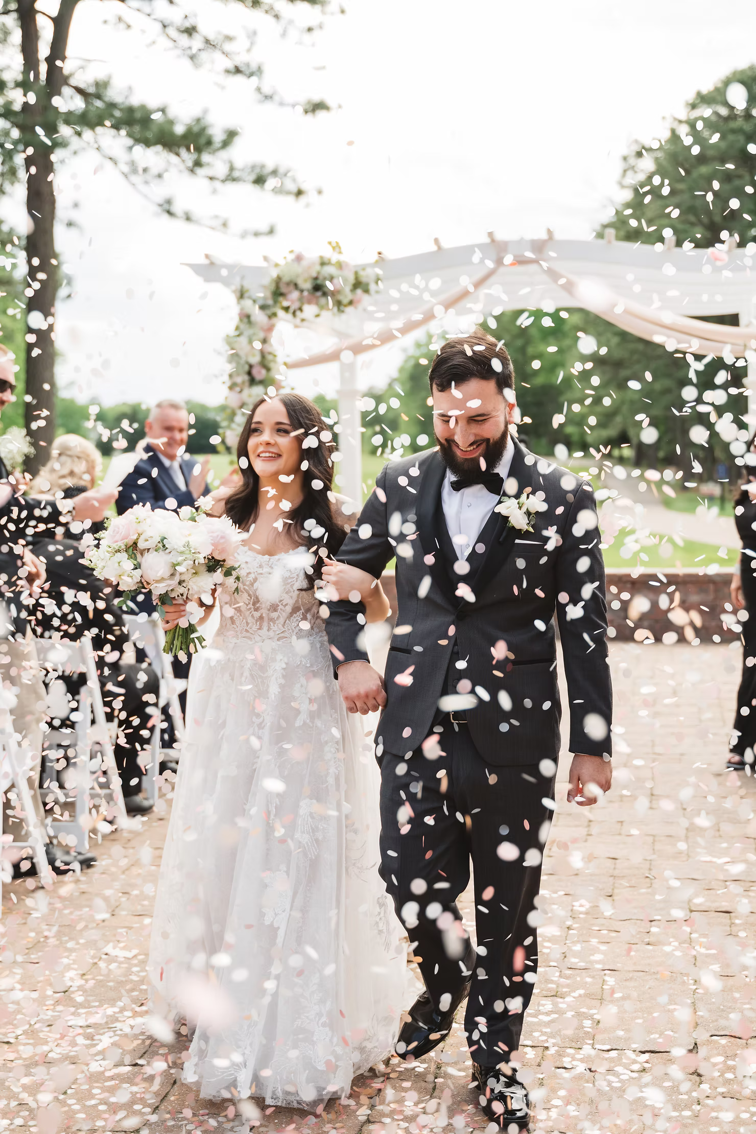 A bride and groom walk up the aisle following their ceremony at Blue Heron Pines to a sea of confetti surrounding them. Taken by NJ wedding photographer Madison Neumann Photography.