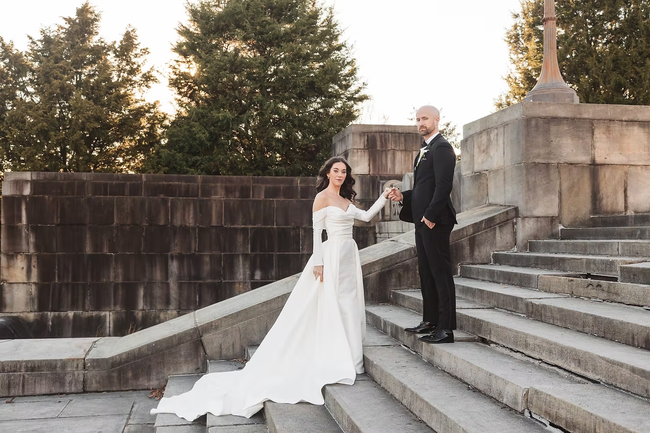 Bride and groom hold hands on the steps of the Philadelphia Museum of Art. Taken by Philadelphia wedding photographer Madison Neumann Photography.