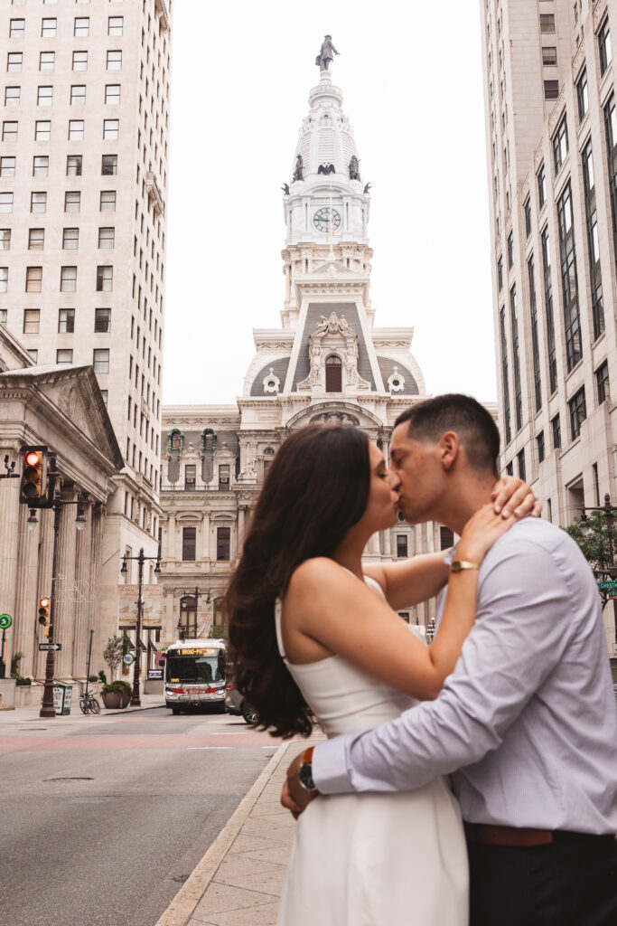 A couple kisses in front of City Hall, Philadelphia on Broad Street. Taken by Philly wedding photographer Madison Neumann Photography. 