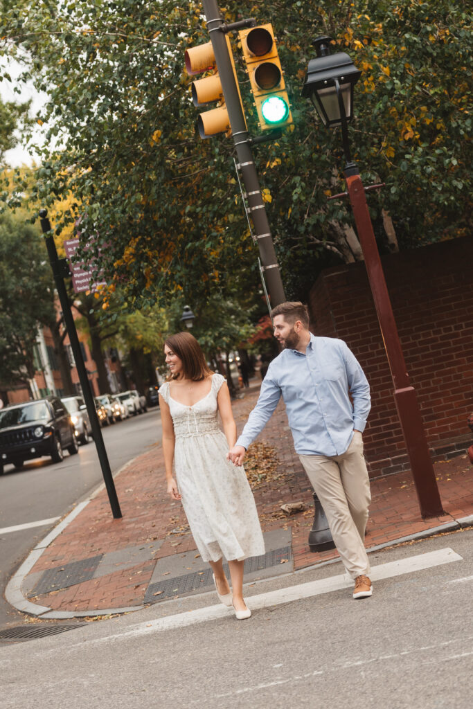 A couple walks together through a crosswalk in Old City, Philadelphia. Taken by Philly wedding photographer Madison Neumann Photography.
