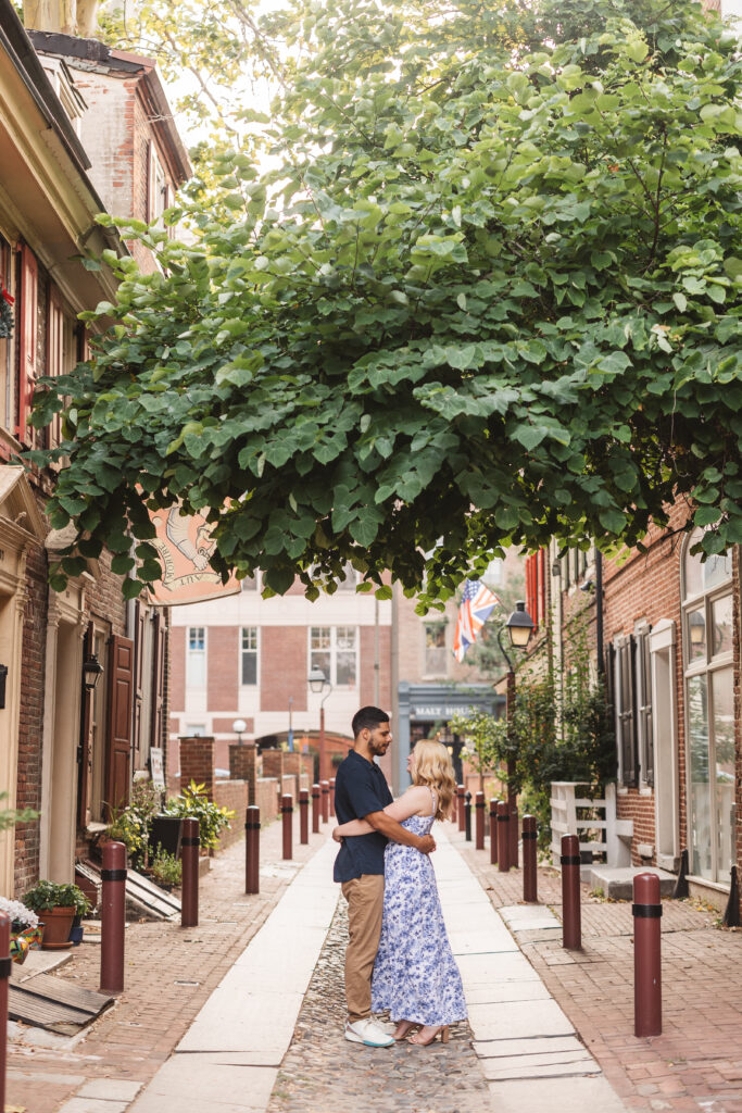 A couple poses together for their engagement photos at Elfreth's Alley in Philadelphia, PA. Taken by philly wedding photographer Madison Neumann Photography.