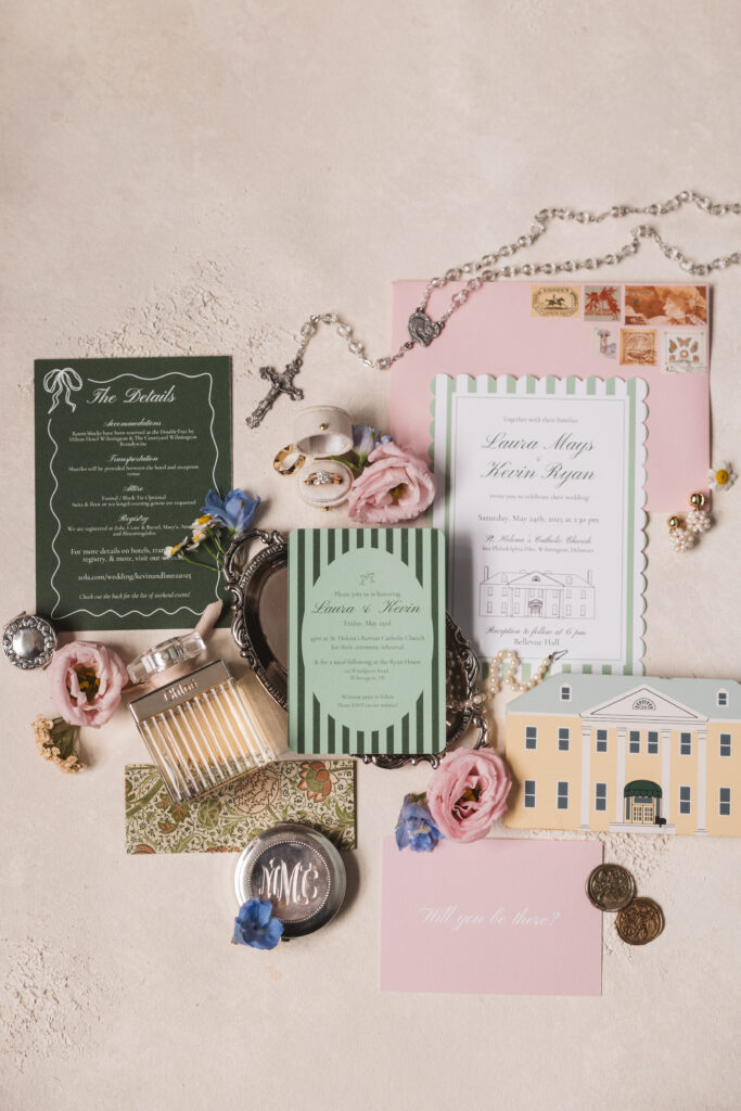 Invitation suite with spring wedding flowers, jewelry and perfume for a wedding day at Bellevue Hall in Delaware. Taken by Delaware wedding photographer Madison Neumann Photography.