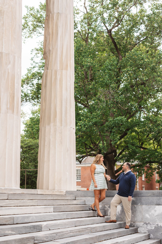 A couple poses together on the stairs of the second bank of the United States in Old City Philadelphia. Taken by Philadelphia Wedding Photographer Madison Neumann Photography.