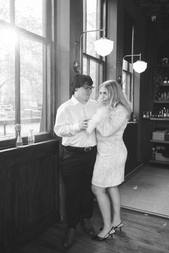 An engaged couple sip drinks in a bar in Philadelphia. Taken by Philadelphia wedding photographer Madison Neumann Photography. 