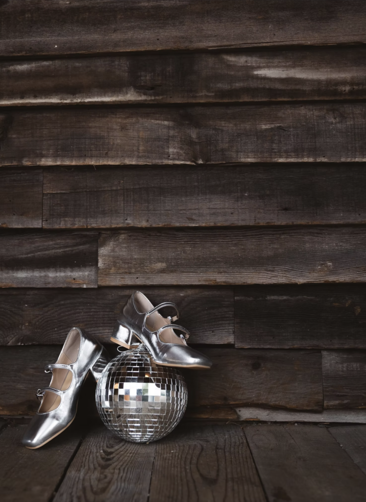 Bride's wedding shoes rest on a disco ball on the front porch of terrain's reception room.