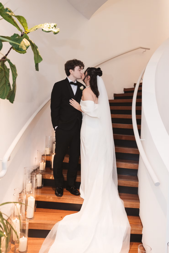 Bride and groom together for a couples portrait on spiral staircase lined with lit candles. Wedding day at Maritime Parc in Jersey City, NJ. Photographed by South Jersey, Philadelphia based wedding photographer Madison Neumann Photography.