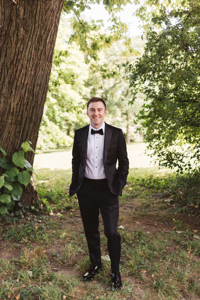Groom smiles for outdoor portrait for wedding at Bartram's Garden in Philadelphia, PA. Photographed by South Jersey Philly wedding photographer Madison Neumann Photography.