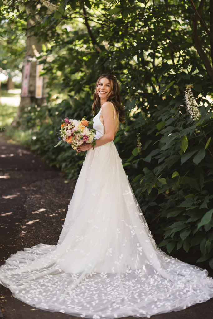 Bridal portrait holding bouquet with gown train in park for wedding at Bartram's Garden in Philadelphia, PA. Photographed by South Jersey Philadelphia wedding photographer Madison Neumann Photography.