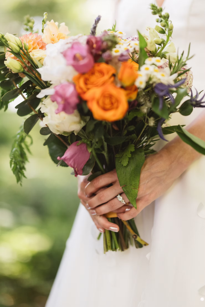 Detail photo of colorful bridal bouquet and wedding band for wedding at Bartram's Garden in Philadelphia, PA. Photographed by South Jersey Philly wedding photographer Madison Neumann Photography.