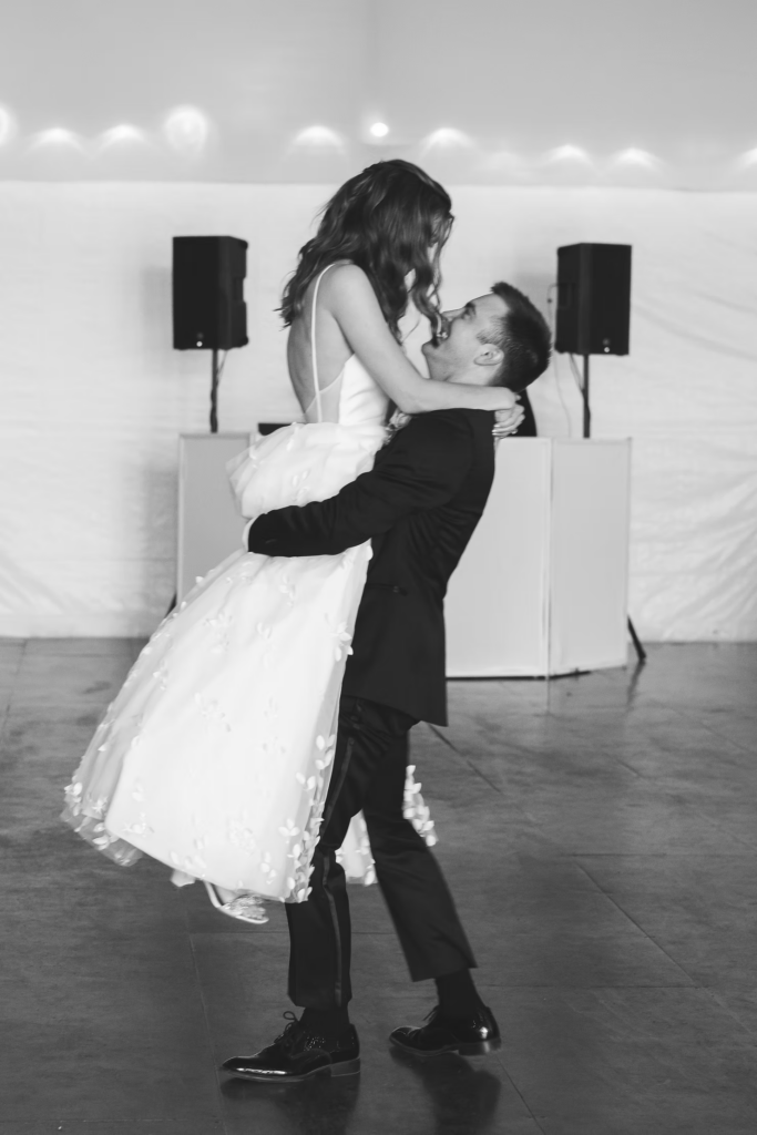 Groom lifts bride on the dance floor for first dance at reception for wedding at Bartram's Garden in Philadelphia, PA. Photographed by South Jersey Philly wedding photographer Madison Neumann Photography.