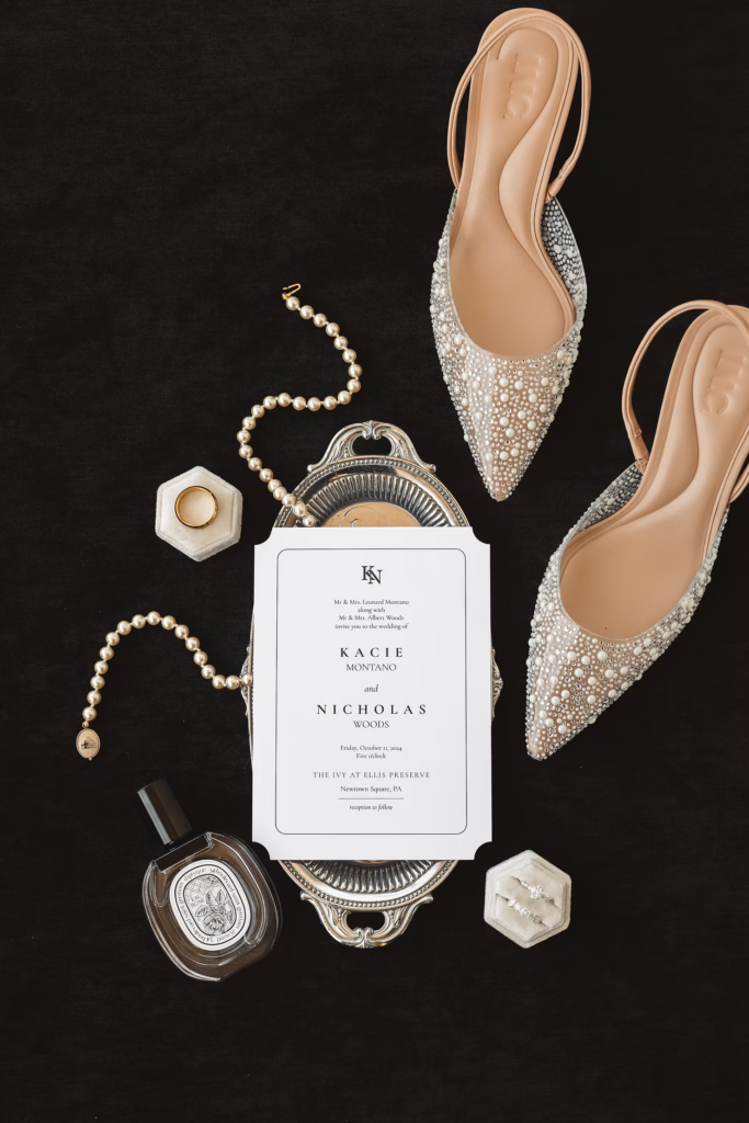 Wedding details with pearl necklace, invitation, bridal shoes, and wedding bands. Photographed for wedding day at The Ivy at Ellis Preserve in Newtown Square, PA. Photographed by South Jersey, Pennsylvania region photographer Madison Neumann Photography.