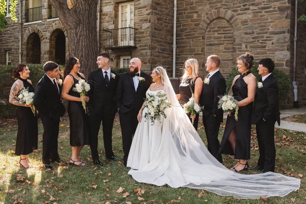 Bride and groom celebrate with wedding party outside venue for wedding day at The Ivy at Ellis Preserve in Newtown Square, PA. Photographed by South Jersey, Pennsylvania region wedding photographer Madison Neumann Photography.