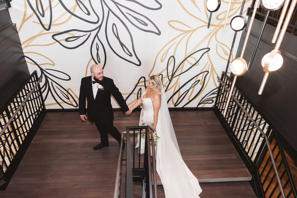 Bride and groom descending steps inside The Ivy at Ellis Preserve by Finley Catering in Newtown Square, PA on wedding day. Photographed by South Jersey, Pennsylvania region wedding photographer Madison Neumann Photography.