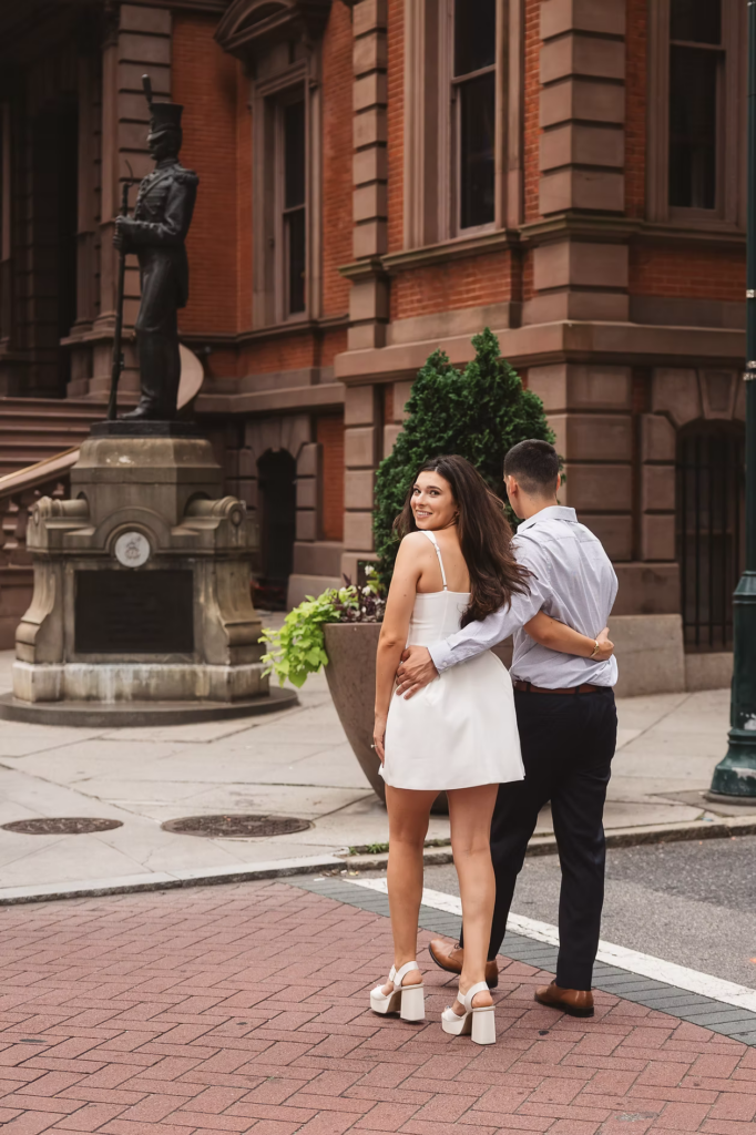 Future bride and groom walk together down the street in Philadelphia for their engagement session photographs. Photographed by Philly, South Jersey based photographer Madison Neumann Photography.