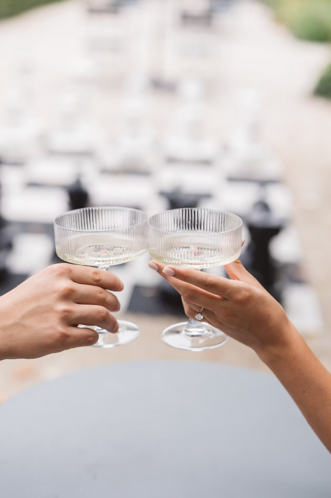 Soon to be bride wears engagement ring for a champagne toast with fiancée. Engagement session photographed at The Rodin Museum in Philadelphia, PA by Madison Neumann Photography.