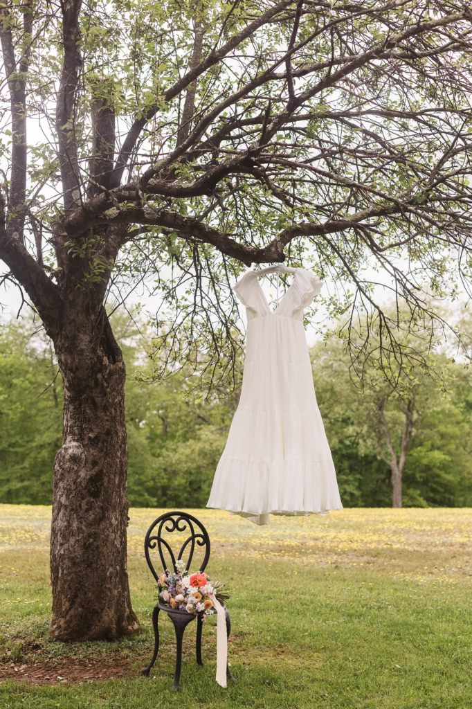 Bride's gown displayed in tree with bouquet for whimsical Pennsylvania wedding in the Pocono Mountains. Photographed by South Jersey Philly Wedding Photographer Madison Neumann Photography.