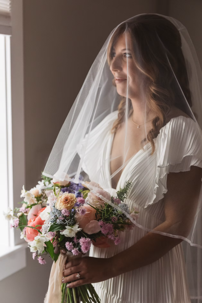 Bride in gown and veil holding bouquet before walking down the aisle for Pennsylvania wedding in the Pocono Mountains. Photographed by South Jersey Philly Wedding Photographer Madison Neumann Photography.