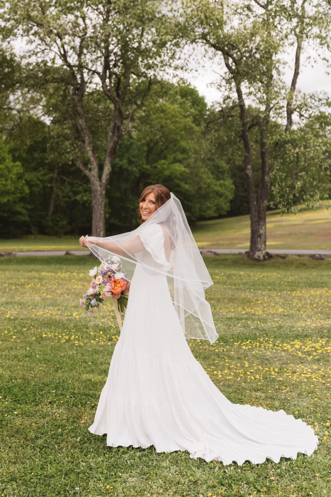 Bride twirls with her veil in flower field for Pennsylvania wedding in the Pocono Mountains at The Lodge at Mountain Springs Lake. Photographed by South Jersey Philly Wedding Photographer Madison Neumann Photography.