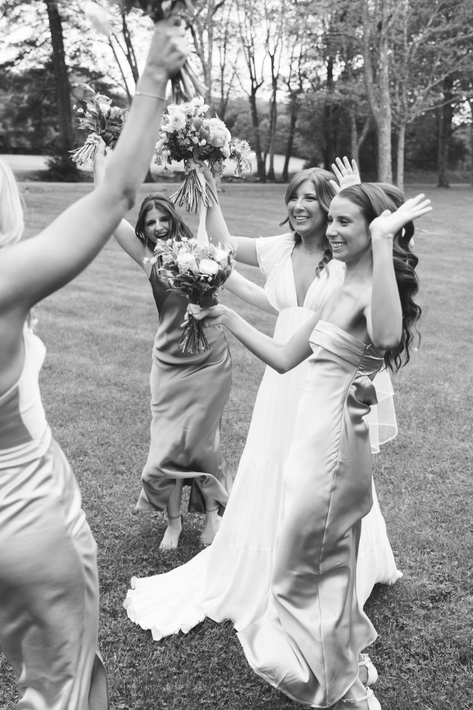 New bride cheers with bridesmaids after ceremony for Pennsylvania wedding in the Pocono Mountains at The Lodge at Mountain Springs Lake. Photographed by South Jersey Philly Wedding Photographer Madison Neumann Photography.