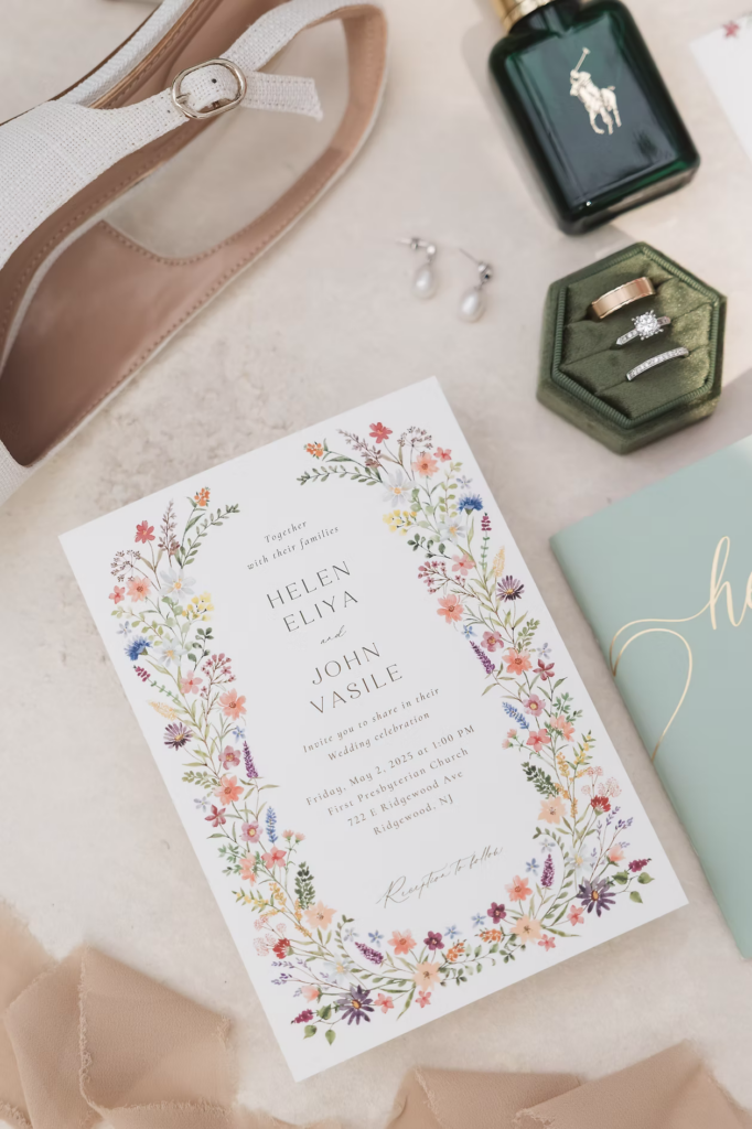 Detail layout of wedding bride's accessories including bridal shoes, pearl earrings, wedding invitation, rings in green ring holder, and vow booklet. Photographed at The Madison Hotel in Morristown, NJ by wedding photographer Madison Neumann Photography.