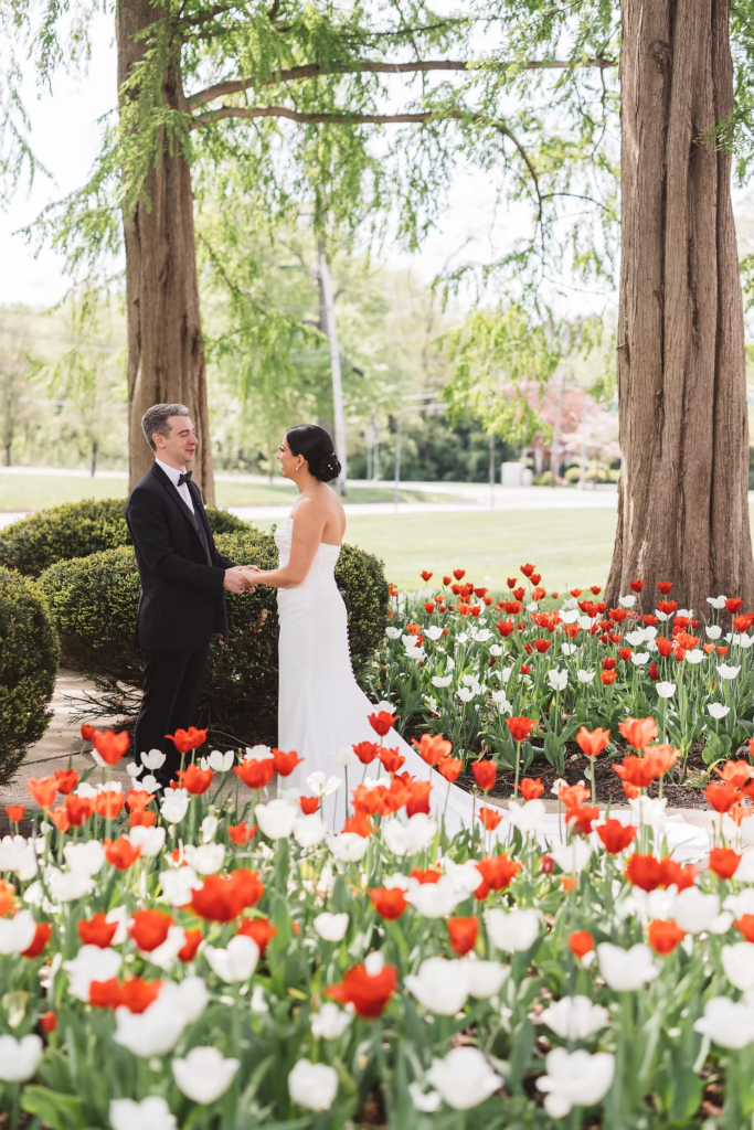 Tulips and greenery surround the bride and groom, holding hands, after seeing each other for the first time on their wedding day. Photographed at The Madison Hotel in Morristown, NJ by wedding photographer Madison Neumann Photography.