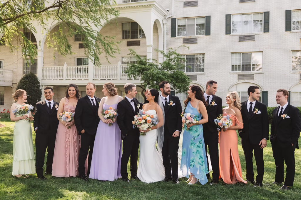 Wedding party with the bride and groom smiling and celebrating the wedding day. Photographed at The Madison Hotel in Morristown, NJ by wedding photographer Madison Neumann Photography.