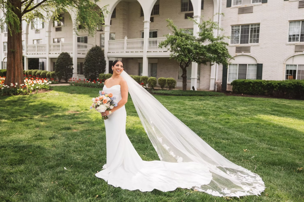 Bride holds bouquet wearing gown and veil on her wedding day outside of venue. Photographed at The Madison Hotel in Morristown, NJ by wedding photographer Madison Neumann Photography.