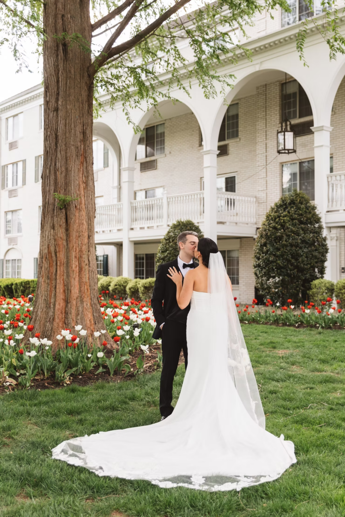 Bride and groom together in front of their venue outside surrounded by tulips. Photographed at The Madison Hotel in Morristown, NJ by wedding photographer Madison Neumann Photography.