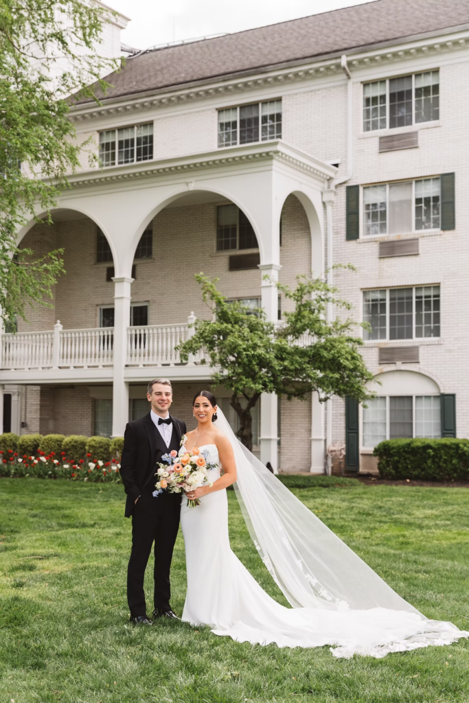 Bride and groom stand together in front of wedding venue. Photographed at The Madison Hotel in Morristown, NJ by wedding photographer Madison Neumann Photography.