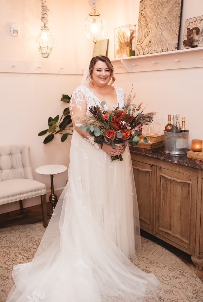 Bride in gown with long sleeves, lace detail, veil, and bouquet after getting ready for her wedding day at Terrain Gardens at DelVal in Doylestown, Pennsylvania. Photographed by South Jersey, Philadelphia based wedding photographer Madison Neumann Photography.