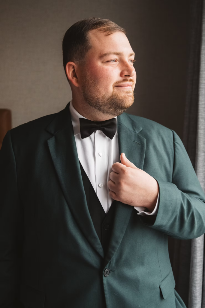 Groom ready for wedding day in green tuxedo suit at Terrain Gardens at DelVal in Doylestown, Pennsylvania. Photographed by South Jersey, Philadelphia based wedding photographer Madison Neumann Photography.