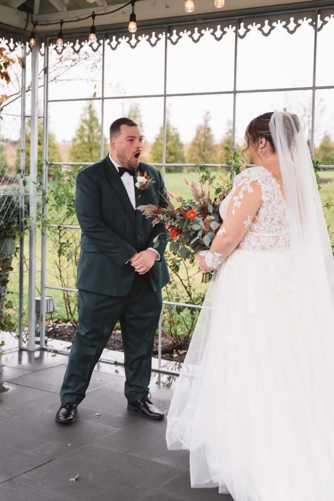 Snow fall outside of venue Terrain Gardens at DelVal in Doylestown, Groom excited to see bride for the first time on their wedding day at Terrain Gardens at DelVal in Doylestown, Pennsylvania. First look photographed by South Jersey, Philly based wedding photographer Madison Neumann Photography.