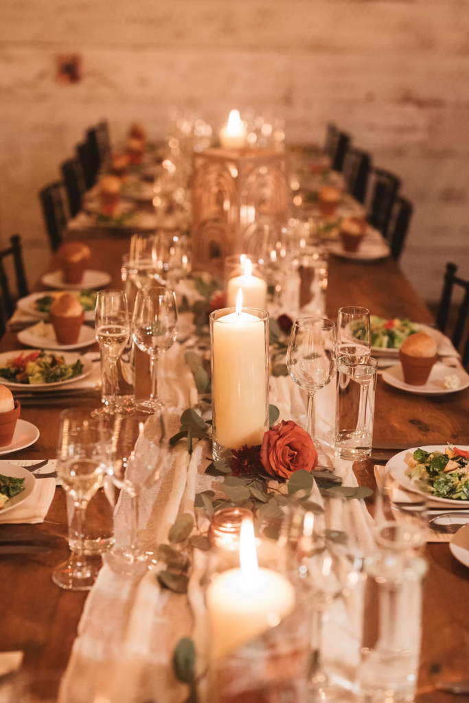 Wedding table details with candles, glasses, table runners, and food. Reception at Terrain Gardens at DelVal in Doylestown, PA. Photographed by South Jersey, Philadelphia based wedding photographer Madison Neumann Photography.