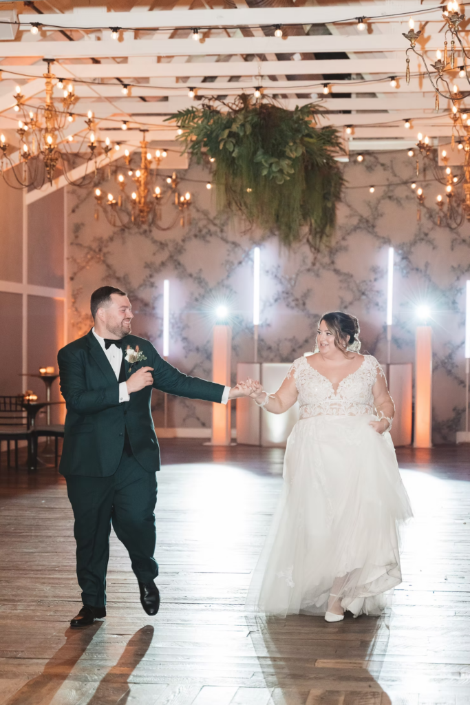 Newlywed bride and groom makes entrance as husband and wife during wedding reception at Terrain Gardens at DelVal in Doylestown, PA. Photographed by South Jersey, Philadelphia based wedding photographer Madison Neumann Photography.