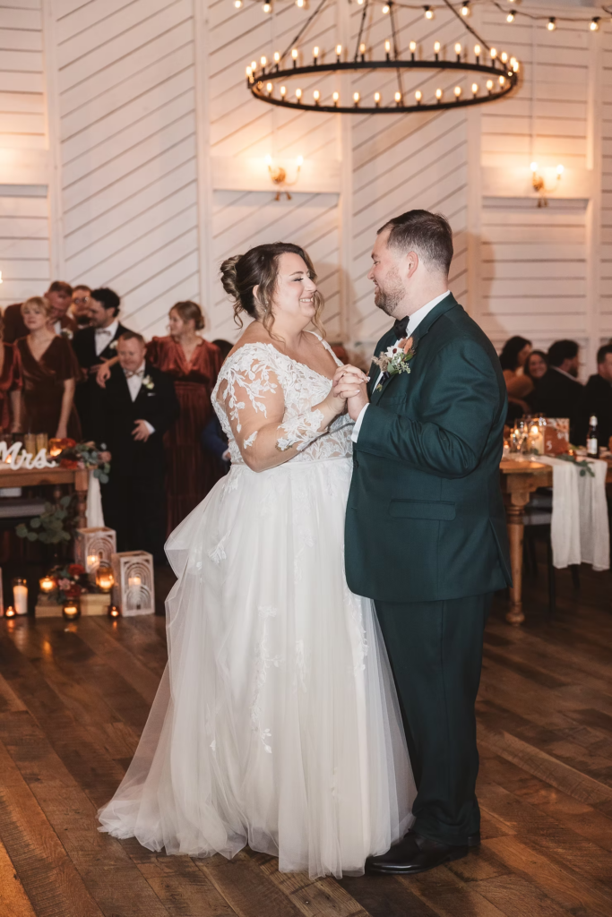 Newlywed bride and groom share first dance as guests watch during reception at Terrain Gardens at DelVal in Doylestown, Pennsylvania. Photographed by South Jersey, Philadelphia based wedding photographer Madison Neumann Photography.