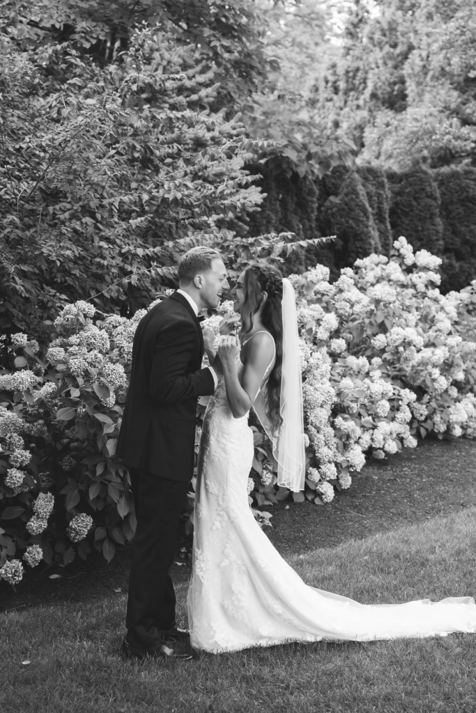Black and white portrait of bride and groom in garden of historic venue for wedding day at The William Penn Inn in Gwynedd, PA. Photographed by Pennsylvania South Jersey area wedding photographer Madison Neumann Photography.