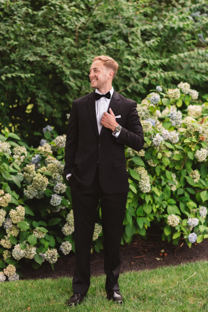 Groom smiles for portrait in garden for wedding day at The William Penn Inn in Gwynedd, PA. Photographed by Pennsylvania South Jersey area wedding photographer Madison Neumann Photography.