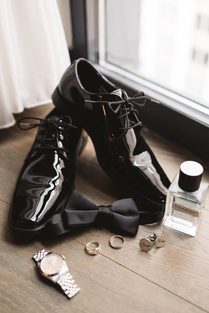 Groom's details including dress shoes, watch, custom cuff links, band, cologne, and bow tie. Wedding day at Maritime Parc in Jersey City, NJ. Photographed by South Jersey, Philadelphia based wedding photographer Madison Neumann Photography.