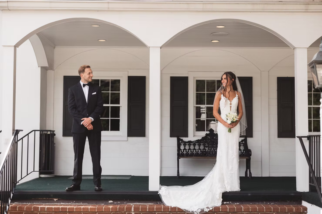 Bride and groom pose on porch of The William Penn Inn in Gwynedd, PA for wedding day. Photographed by Pennsylvania South Jersey area wedding photographer Madison Neumann Photography.