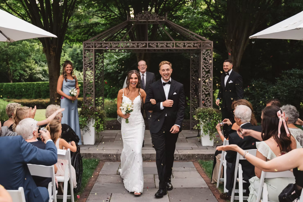 Wedding guests celebrate bride and groom by tossing confetti for wedding day at The William Penn Inn in Gwynedd, PA. Photographed by Pennsylvania South Jersey area wedding photographer Madison Neumann Photography.
