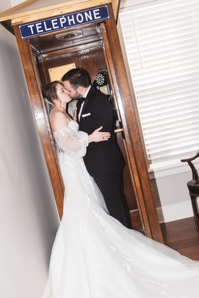 Bride and groom in antique telephone booth for wedding day formal portraits at David's Country Inn in Hackettstown, NJ. Photographed by South Jersey, Philadelphia based wedding photographer Madison Neumann Photography.