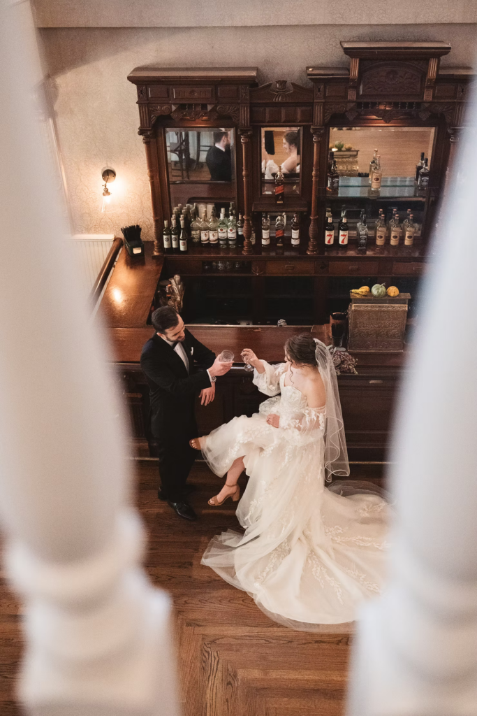 Bride and groom cheers with cocktails at the antique bar at David's Country Inn in Hackettstown, New Jersey. Photographed by South Jersey, Philadelphia based wedding photographer Madison Neumann Photography.