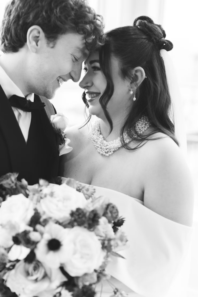 Bride holds bouquet and smiles with her groom. Wedding day at Maritime Parc in Jersey City, NJ. Photographed by South Jersey, Philadelphia based wedding photographer Madison Neumann Photography.