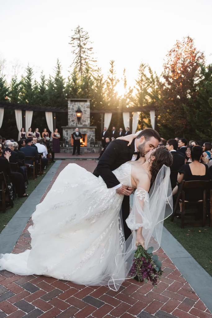 Newlywed bride and groom walk down the aisle after wedding ceremony as husband and wife. Outdoor ceremony in from of fireplace at David's Country Inn in Hackettstown, NJ. Photographed by South Jersey, Philadelphia based wedding photographer Madison Neumann Photography.
