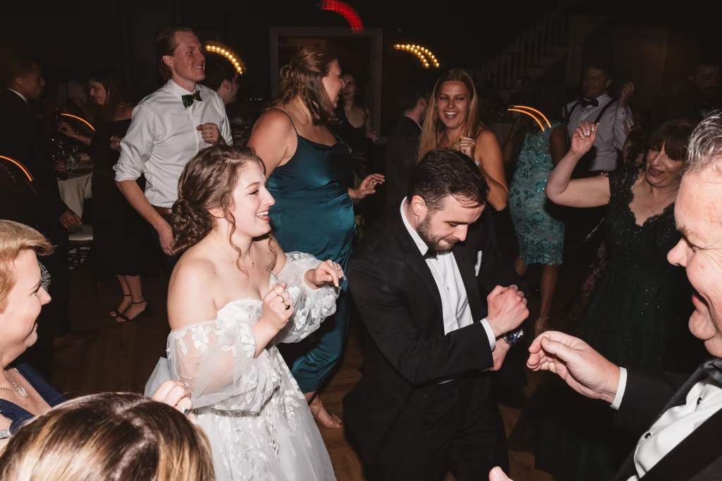 Bride and groom dance with guests during wedding reception at David's Country Inn in Hackettstown, New Jersey. Photographed by South Jersey, Philadelphia based wedding photographer Madison Neumann Photography.