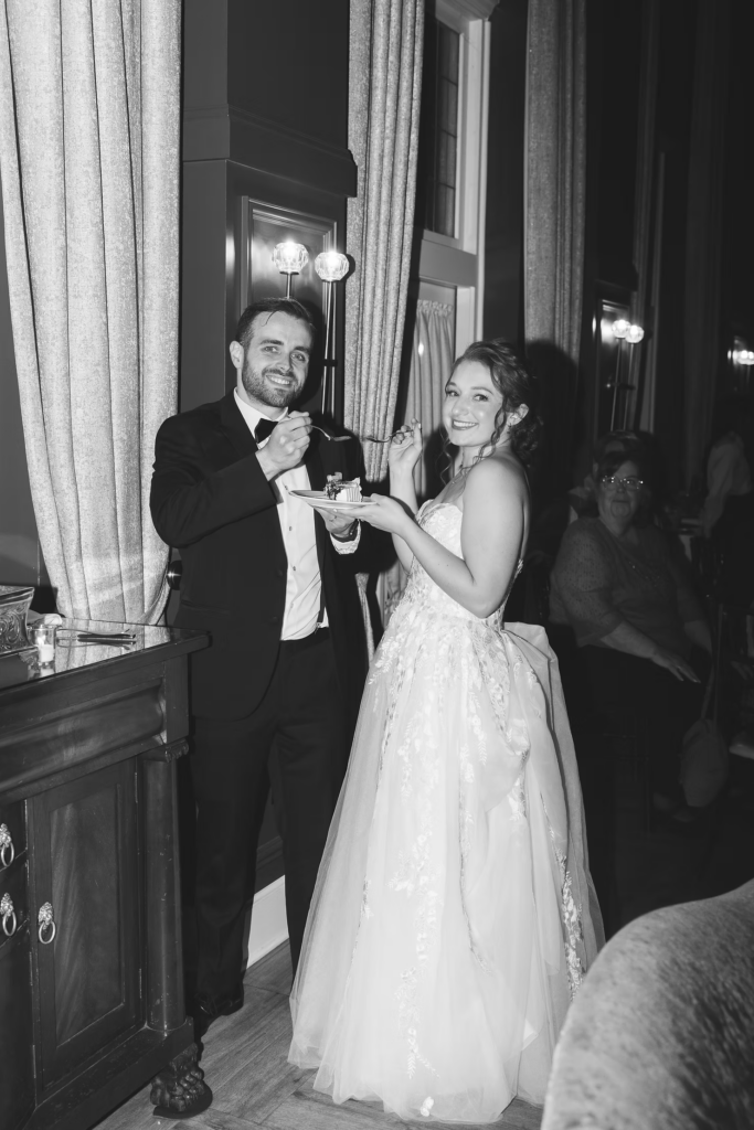 Newlywed bride and groom share first slice of wedding cake during reception at David's Country Inn in Hackettstown, NJ. Photographed by South Jersey, Philadelphia based wedding photographer Madison Neumann Photography.