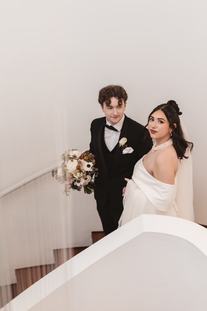 Bride and groom walk down staircase together. Wedding day at Maritime Parc in Jersey City, NJ. Photographed by South Jersey, Philadelphia based wedding photographer Madison Neumann Photography.