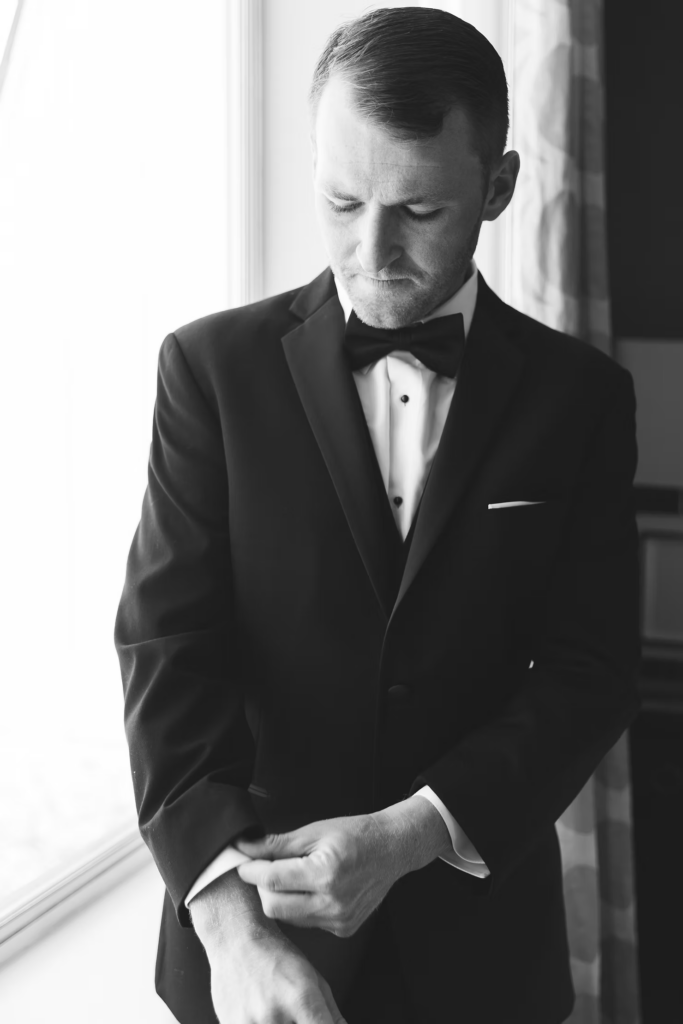 Groom finished getting ready for wedding day wearing suit, bowtie, and cufflinks. Wedding day at Downingtown Country Club in Downingtown, PA. Photographed by South Jersey, Philadelphia based wedding photographer Madison Neumann Photography.