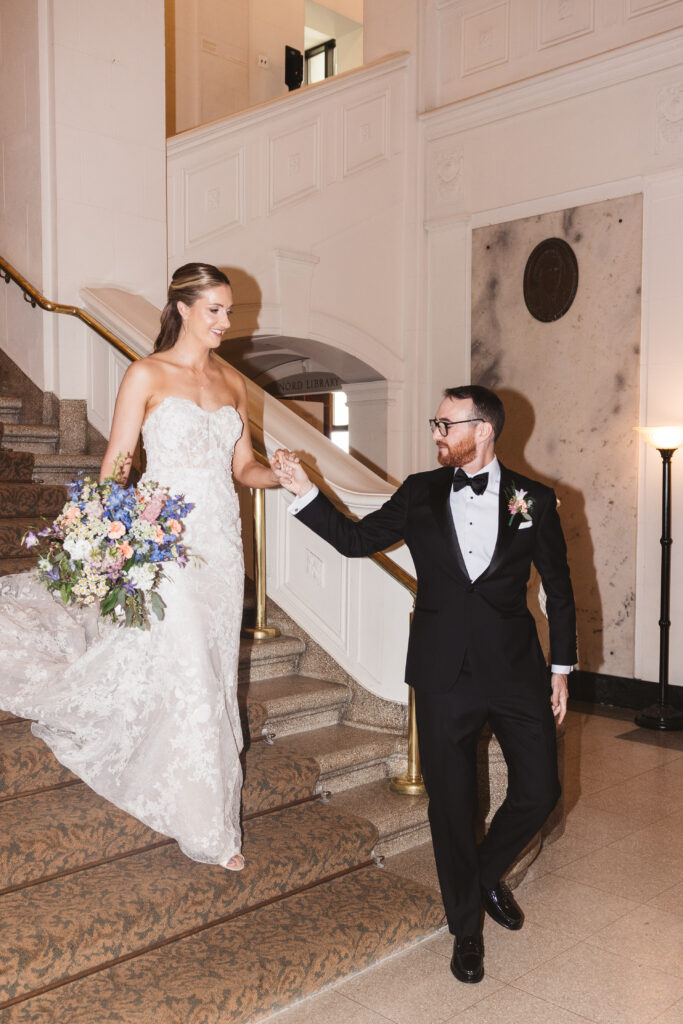 Bride and groom walk together holding hands down the steps. Wedding day at the American Swedish Historical Museum in Philadelphia, PA. Photographed by South Jersey/Philly based wedding photographer Madison Neumann Photography.