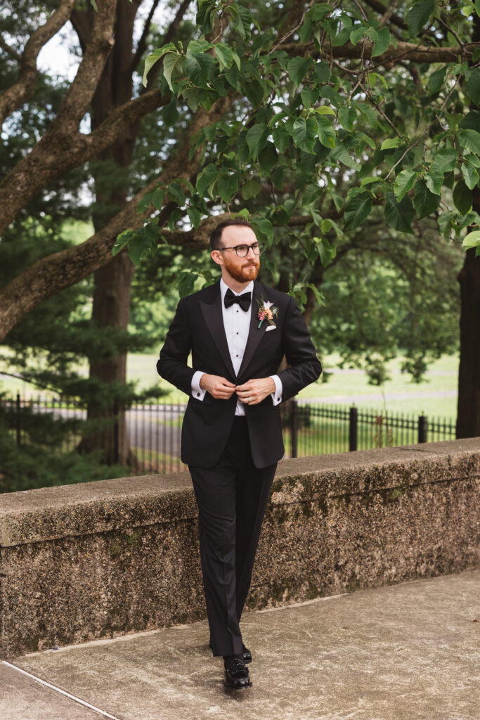 Groom in full black tuxedo suit and boutonniere outside venue. Wedding day at the American Swedish Historical Museum in Philadelphia, PA. Photographed by South Jersey/Philly based wedding photographer Madison Neumann Photography.